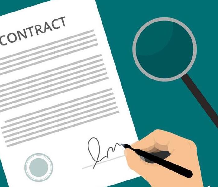 An individual looking a legal contract with a magnifying glass and then signing the contract