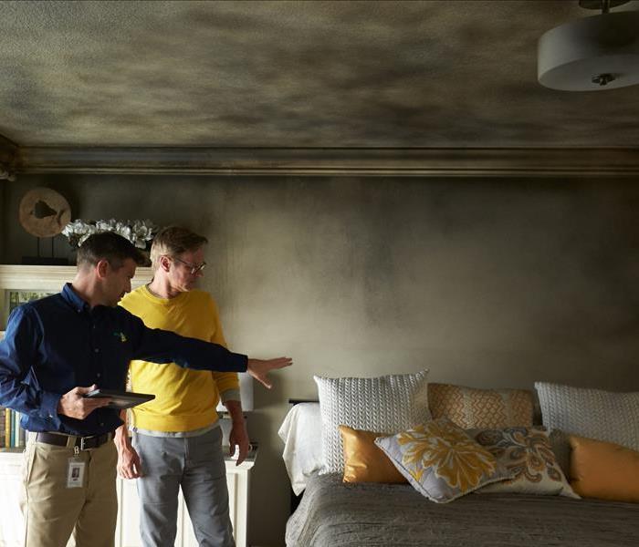 Professional walking through the smoke-damaged home with homeowner