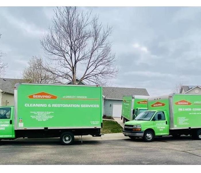 Three SERVPRO trucks onsite at a local loss, and parked outside the residence.