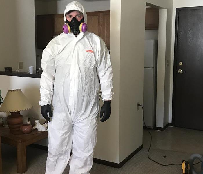 SERVPRO technician in a biohazard suit and full face respirator