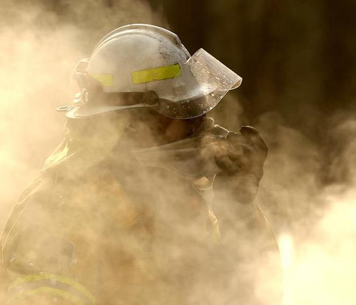Fireman standing in a smoke filled area.